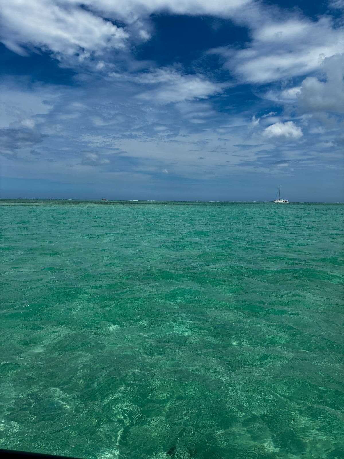 Lagon bleu intense de Blue Bay avec bateaux à fond de verre